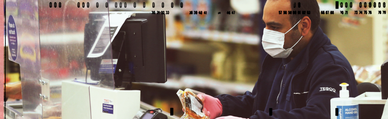 A supermarket worker wearing a face mask.
