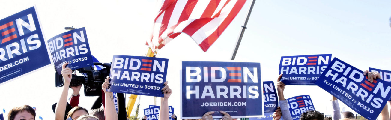 Crowds holding Biden-Harris placards celebrate the announcement of their victory in the US election