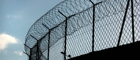Silhouette of concertina barbed wire on a prison fence