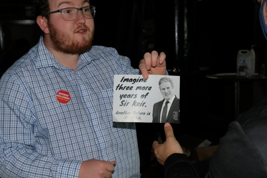 A campaigner holds a leaflet saying 'imagine three more years of sir Kier'