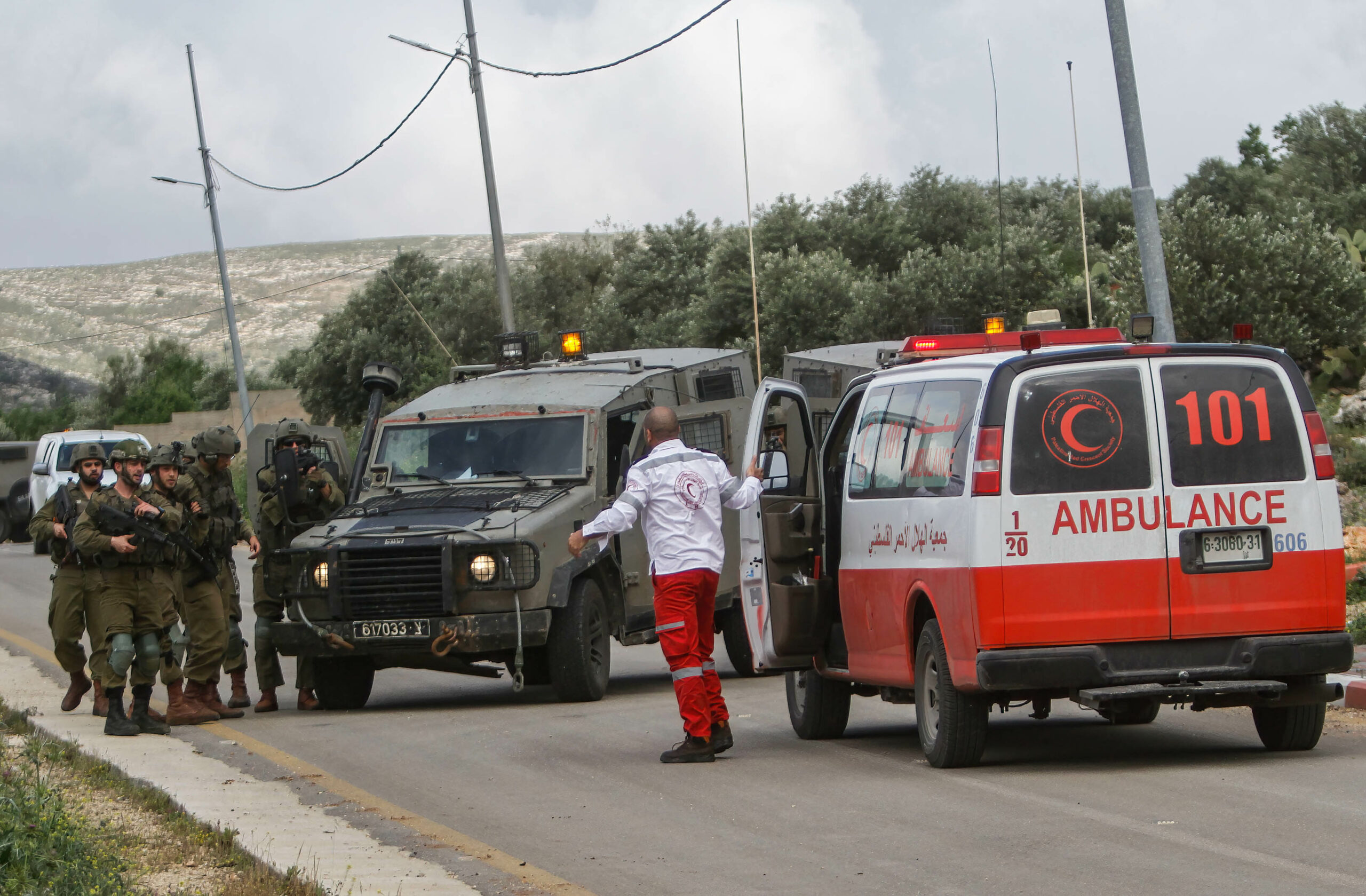 Israeli army forces prevent a Palestinian ambulance from approaching the site of casualties