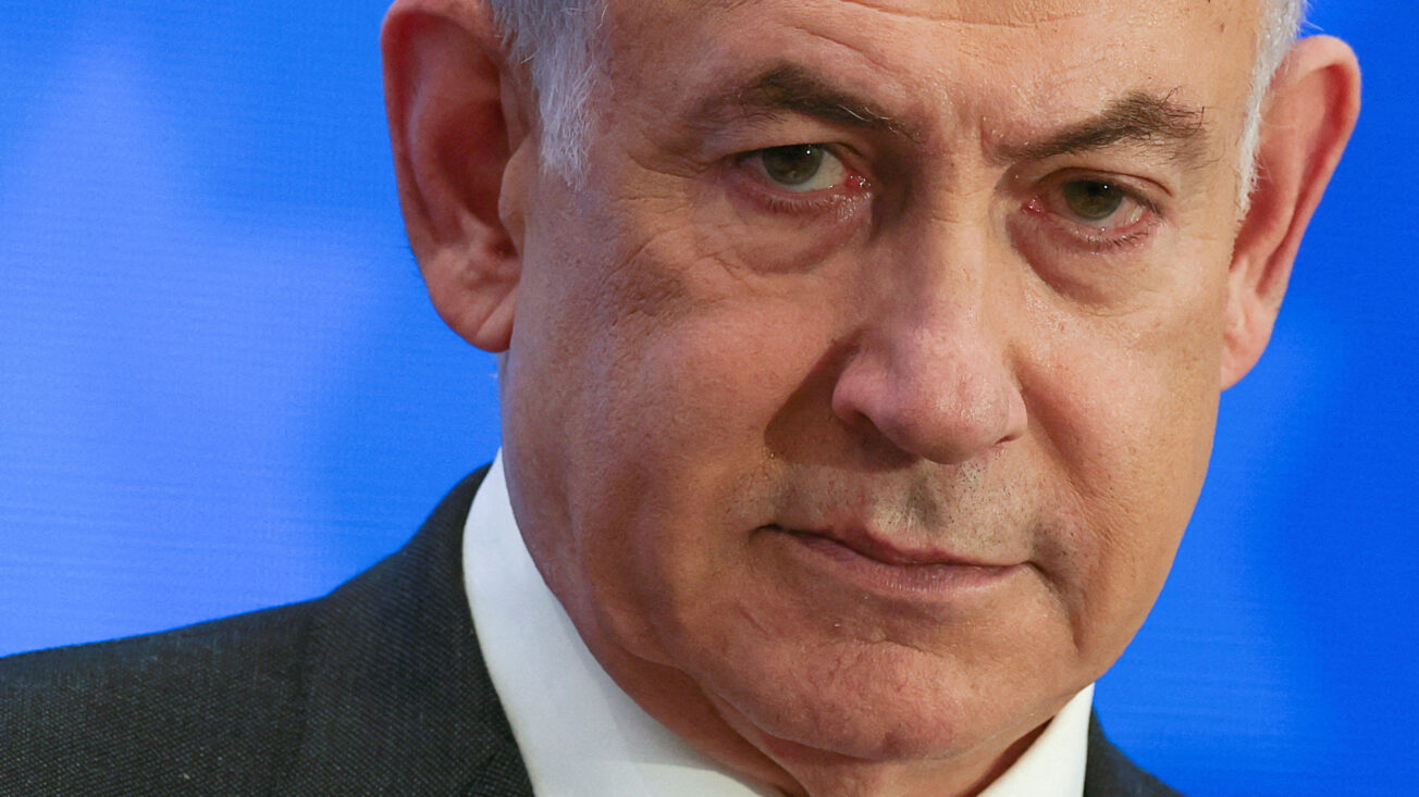 a man with grey hair and a suit looks downcast