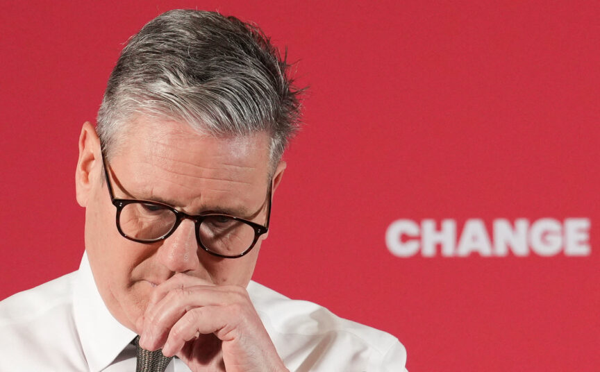 Keir Starmer looks sad behind a red background that says 'change'