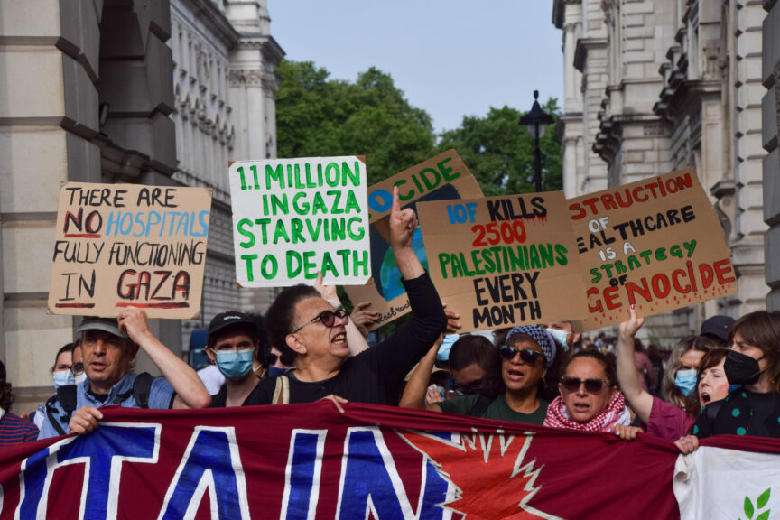 Protesters hold placards condemning Israel's genocide in Gaza and the UK government's complicity
