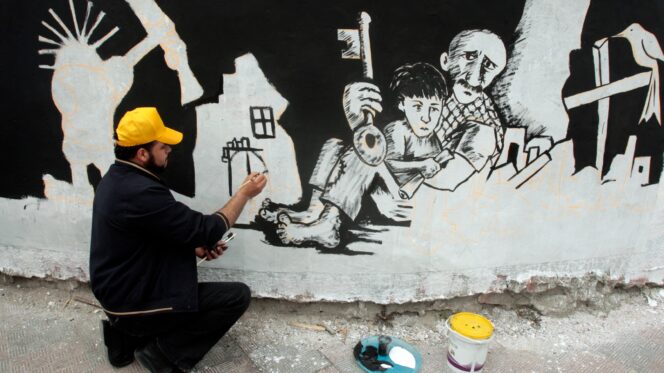 A Palestinian artist draws a mural depicting ‘Nakba’ in Gaza City, 14 May 2011.