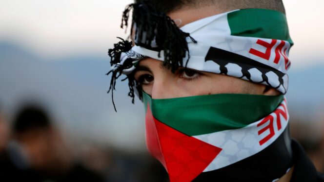 A youth with a scarf in Palestinian colours takes part in a protest in Majd al-Krum, northern Israel, October 2019. Ammar Awad/Reuters