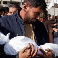 A man carries the dead body of a child as he attends the funeral of Palestinians killed in Israeli strikes, in Khan Younis, southern Gaza Strip, 3 May 2025. Hatem Khaled/Reuters