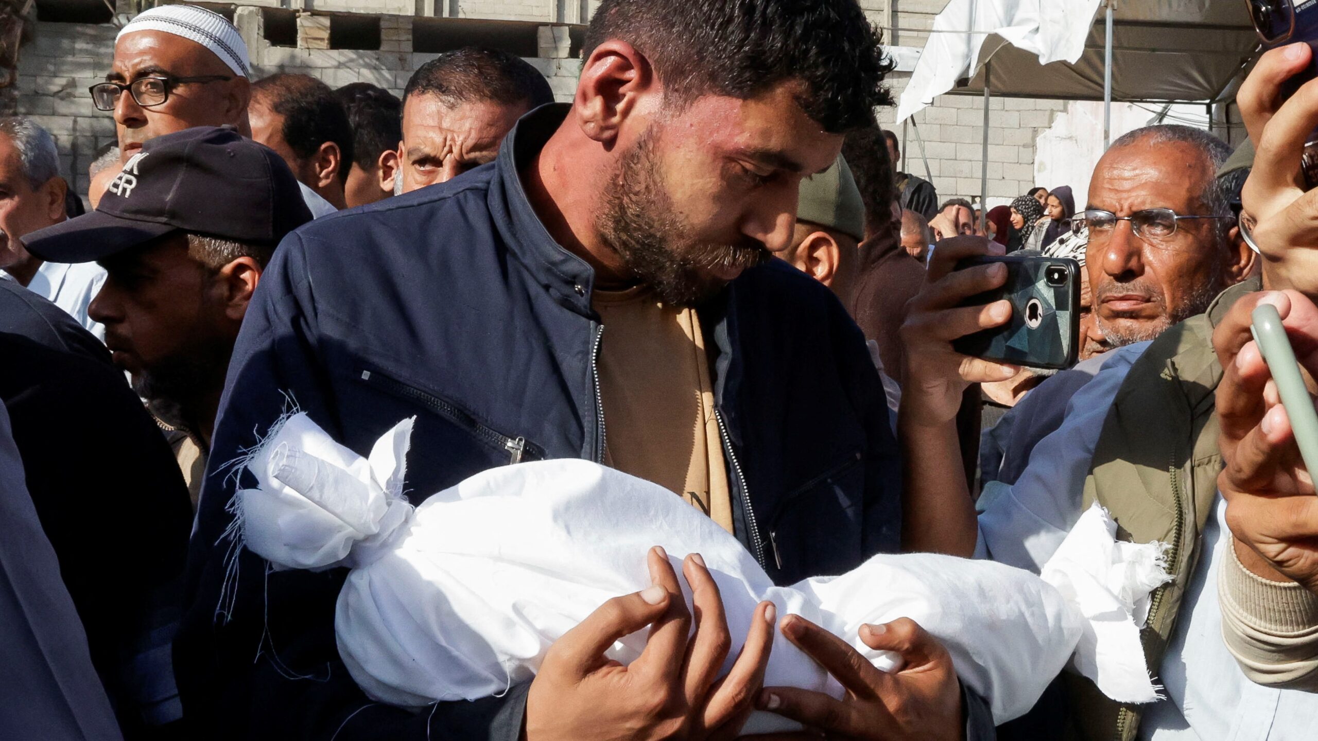 A man carries the dead body of a child as he attends the funeral of Palestinians killed in Israeli strikes, in Khan Younis, southern Gaza Strip, 3 May 2025. Hatem Khaled/Reuters
