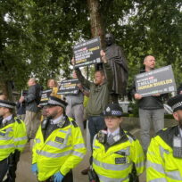 Counter protesters hold up signs that claim there are '2 million human shields in Gaza' and are protected by the police.
