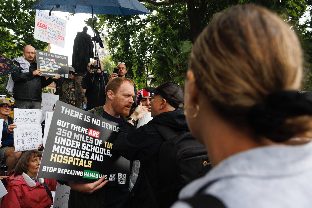 A counter protester holds a sign denying genocide in Gaza.