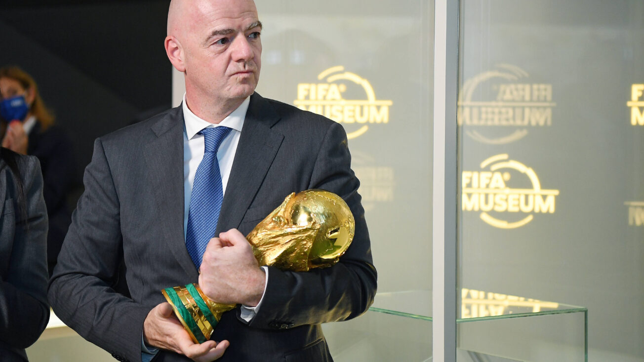 A bald man clutches a gold trophy