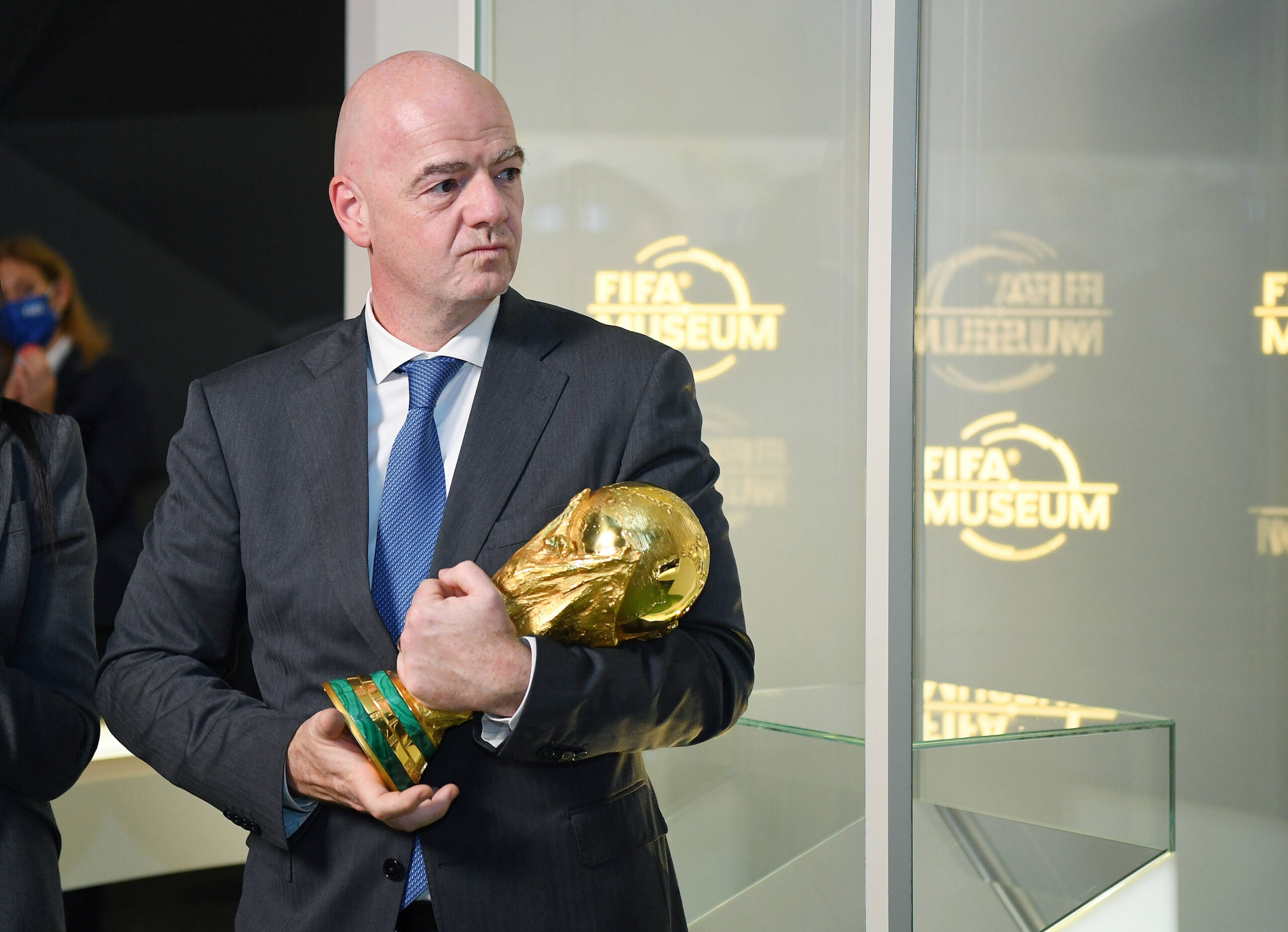 A bald man clutches a gold trophy