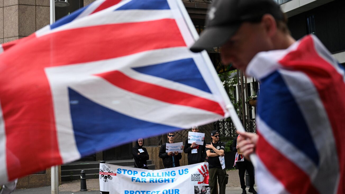 A demonstrator holds a Union Jack flag, during an anti-immigration protest outside the Britannia International Hotel in Canary Wharf, London, Britain, July 27, 2025. Photo: REUTERS/Jaimi Joy