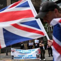 A demonstrator holds a Union Jack flag, during an anti-immigration protest outside the Britannia International Hotel in Canary Wharf, London, Britain, July 27, 2025. Photo: REUTERS/Jaimi Joy
