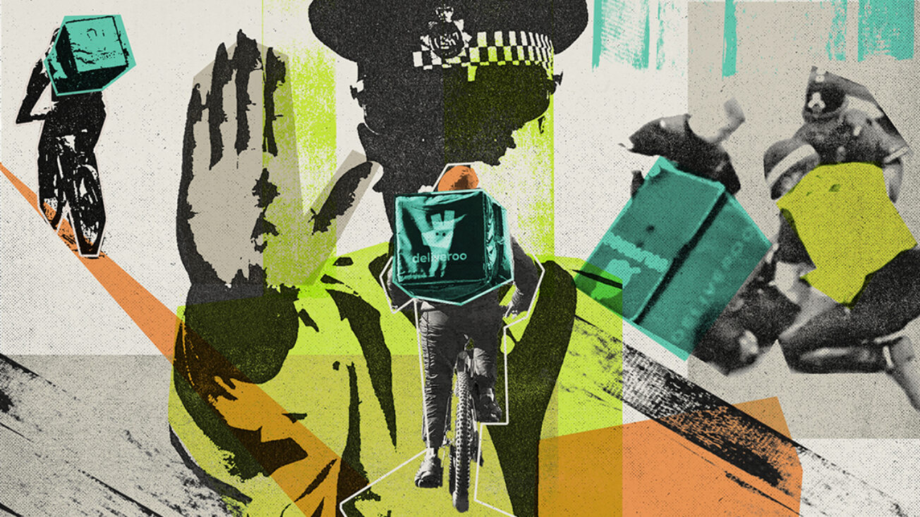 A police officer holds up a hand with a delivery courier riding towards them in the foreground