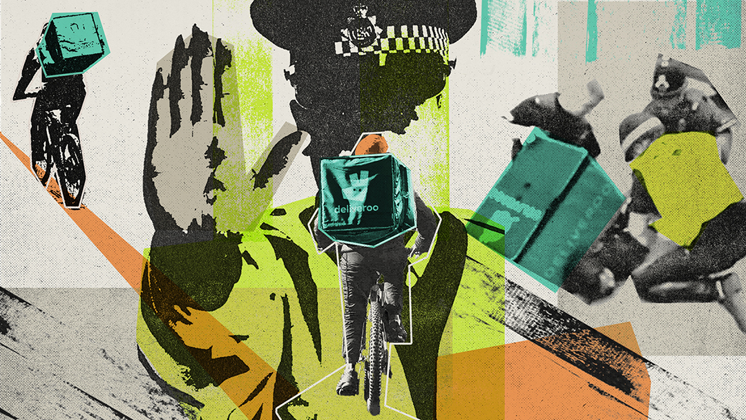 A police officer holds up a hand with a delivery courier riding towards them in the foreground