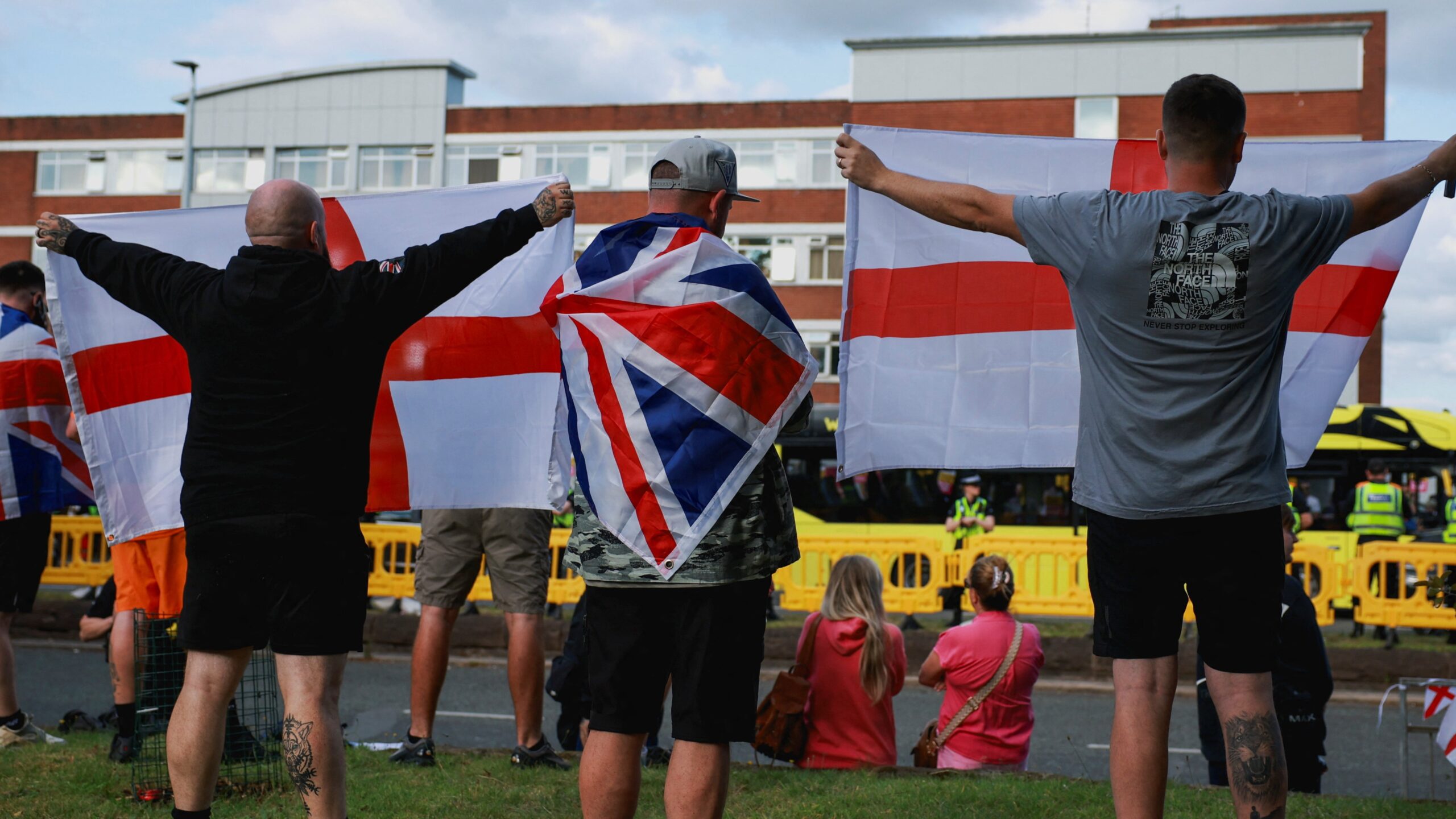 Anti-immigration demonstrators display Union Jack and England flags as they gather outside a hotel in Altrincham, 8 August 2025. Phil Noble/Reuters