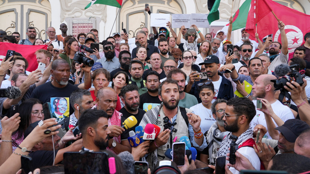 Thiago Avila is surrounded by people at a press conference in Tunis.