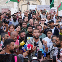 Thiago Avila is surrounded by people at a press conference in Tunis.