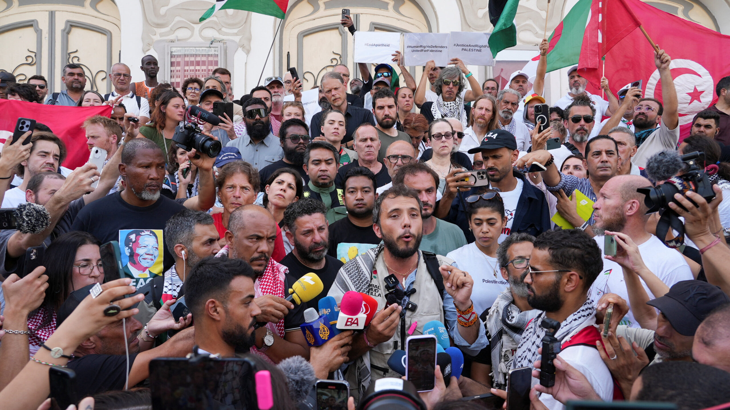 Thiago Avila is surrounded by people at a press conference in Tunis.