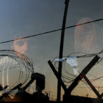 Palestinian prisoner stares out of a bus window as he and other prisoners leave Ketziot military prison in southern Israel, in June 2005. REUTERS/Ronen Zvulun