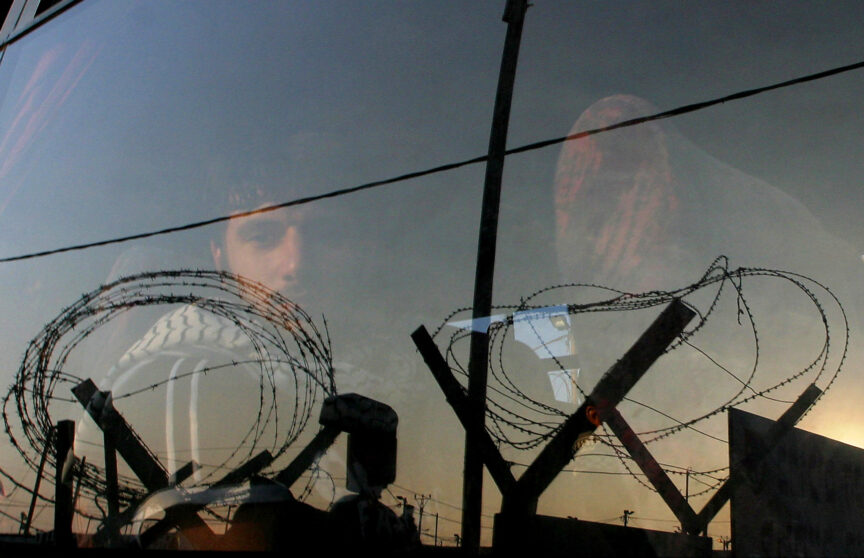 Palestinian prisoner stares out of a bus window as he and other prisoners leave Ketziot military prison in southern Israel, in June 2005. REUTERS/Ronen Zvulun