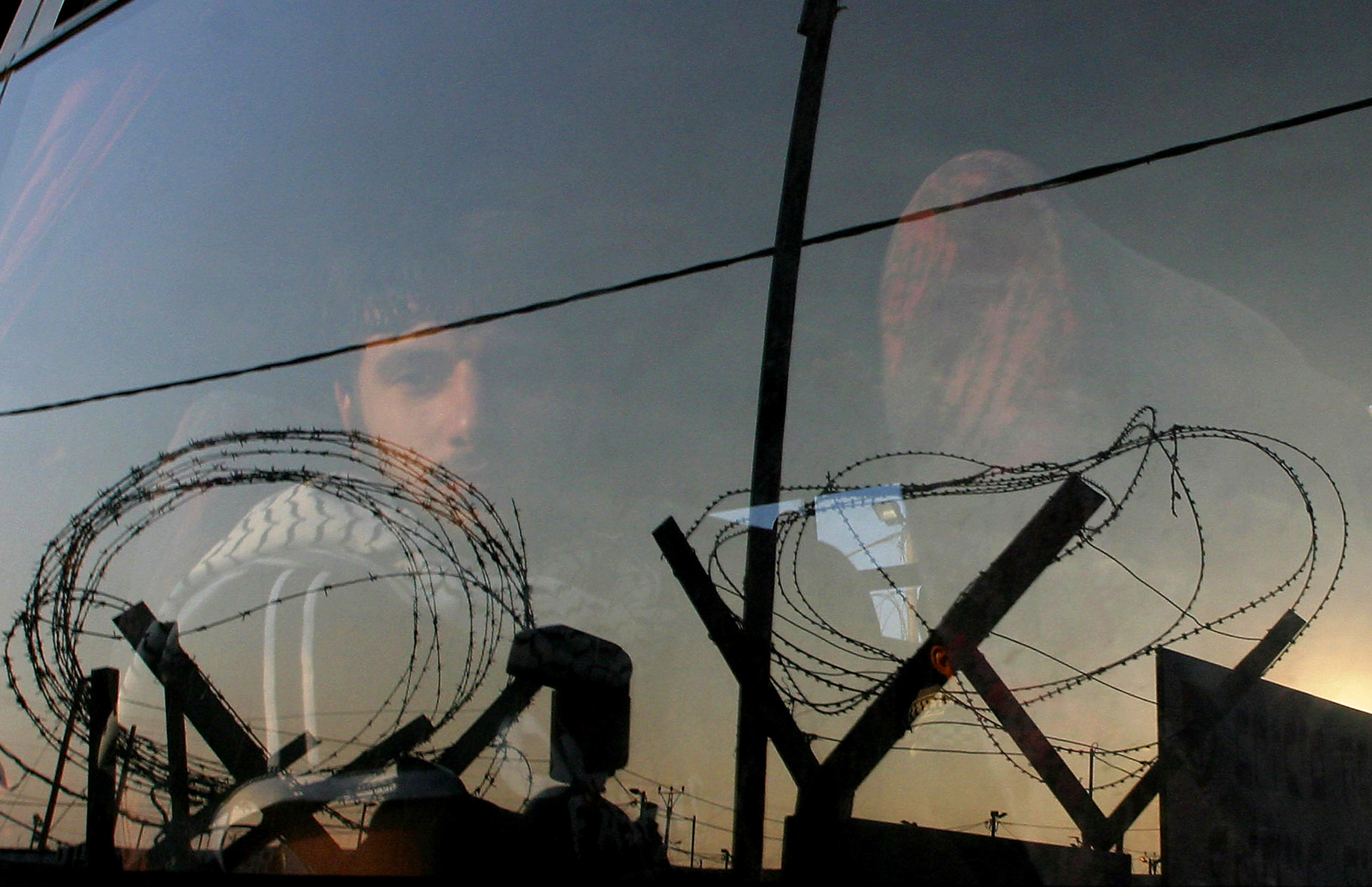 Palestinian prisoner stares out of a bus window as he and other prisoners leave Ketziot military prison in southern Israel, in June 2005. REUTERS/Ronen Zvulun
