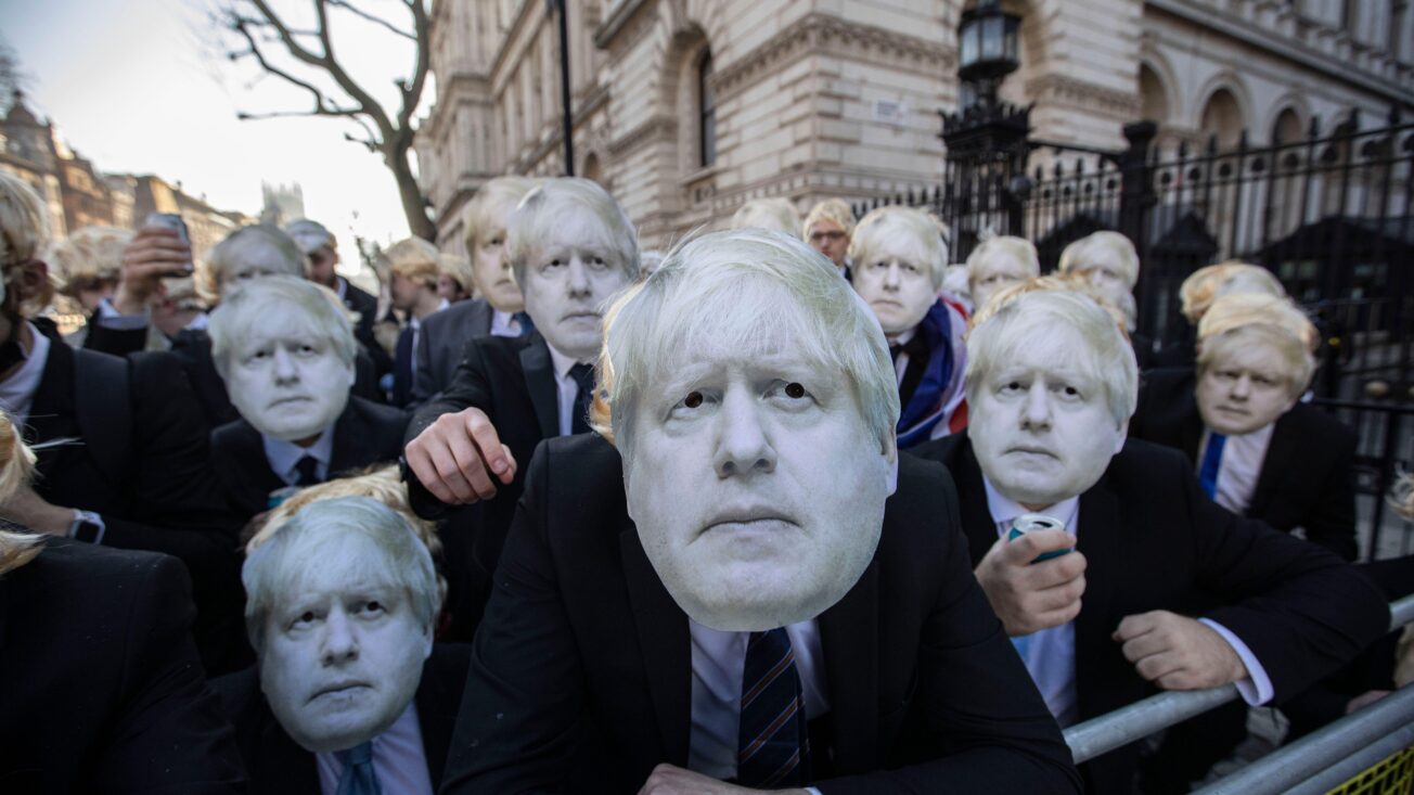 Flash-mob of ‘partygate’ anti-Boris Johnson protesters wearing floppy blond wigs and Boris Johnson masks and suits gathered outside Downing Street after the UK prime minister was put under investigation for holding a drinks party at No 10 on various occasions, breaking the Covid lockdown restrictions, 14 January 2022. Jeff Gilbert/Alamy Live News