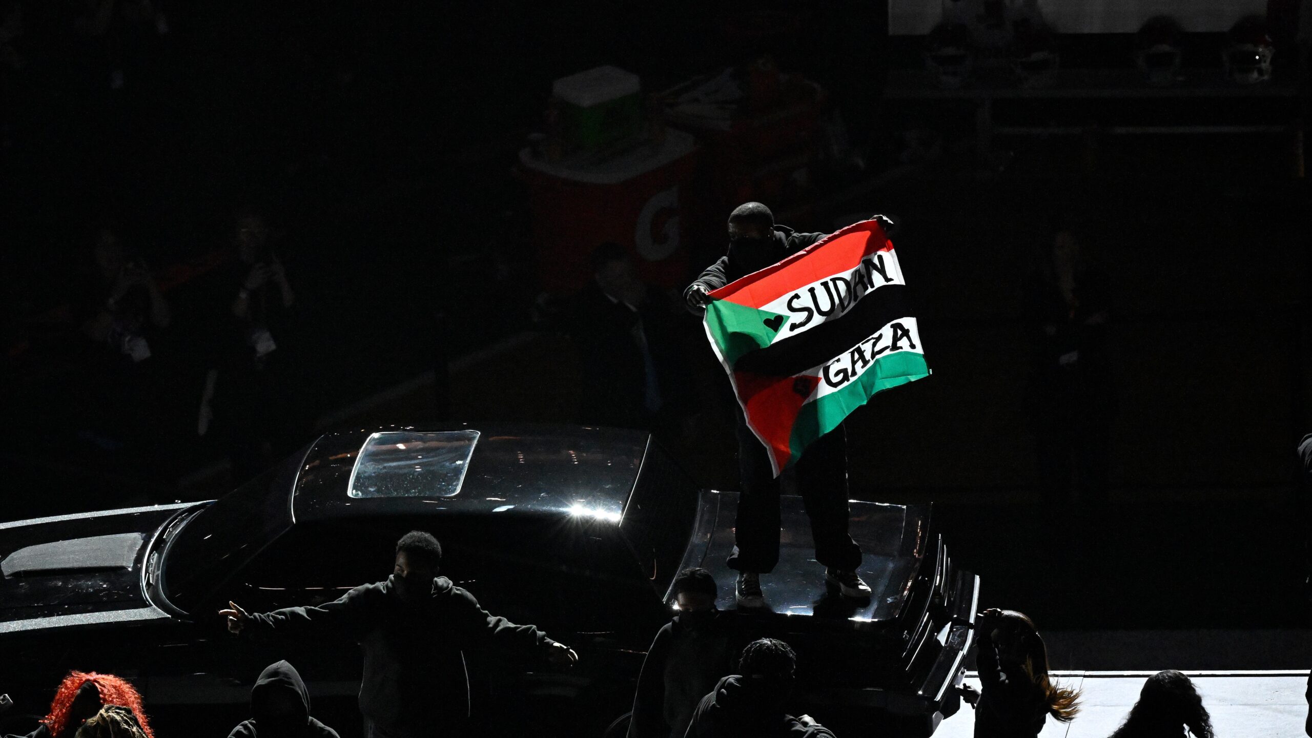 February 9, 2025, New Orleans LA; A protestor displays a flag with Sudan and Gaza printed on it during the halftime performances of Super Bowl LIX between the Philadelphia Eagles and the Kansas City Chiefs at Caesars Superdome. Mandatory credit Eric Canha/CSM/Sipa USA (Credit Image: © Eric Canha/Cal Sport Media/Sipa USA)