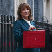 woman with brown hair poses with red box