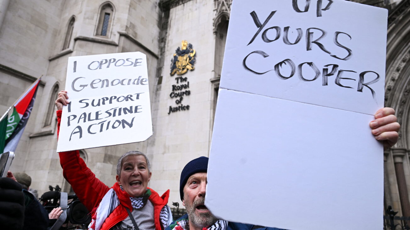 Protesters hold signs outside the High Court, after judges ruled the British government’s decision to designate pro‑Palestinian group Palestine Action as a terrorist organisation unlawful, in London, Britain, 13 February 2026. Reuters/Jaimi Joy