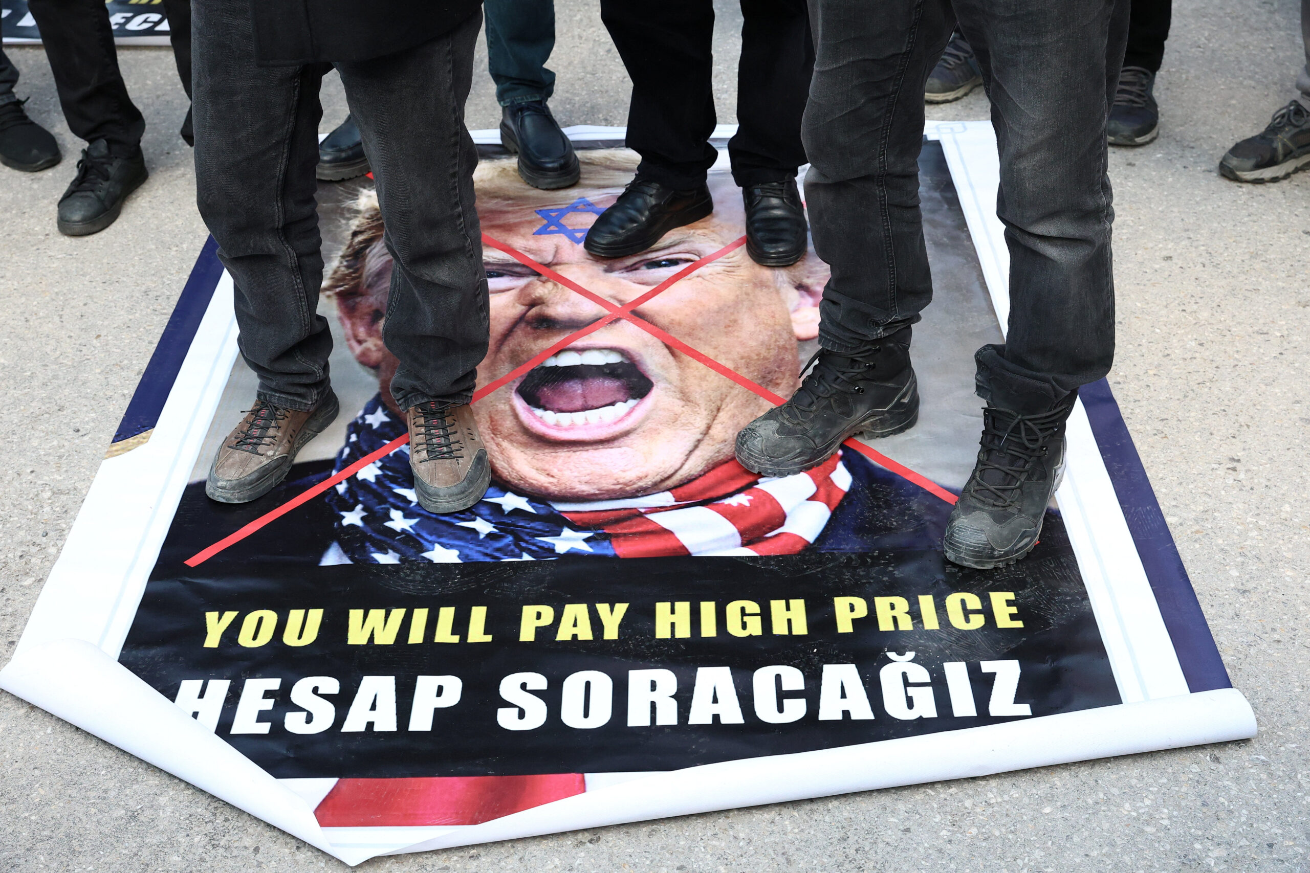 Demonstrators step on a poster of US president Donald Trump during a protest against Israel and the US’s strikes on Iran, following the killing of late Iran’s supreme leader Ayatollah Ali Khamenei, outside the US embassy in Ankara, Turkey, 1 March 2026. Reuters/Efekan Akyuz