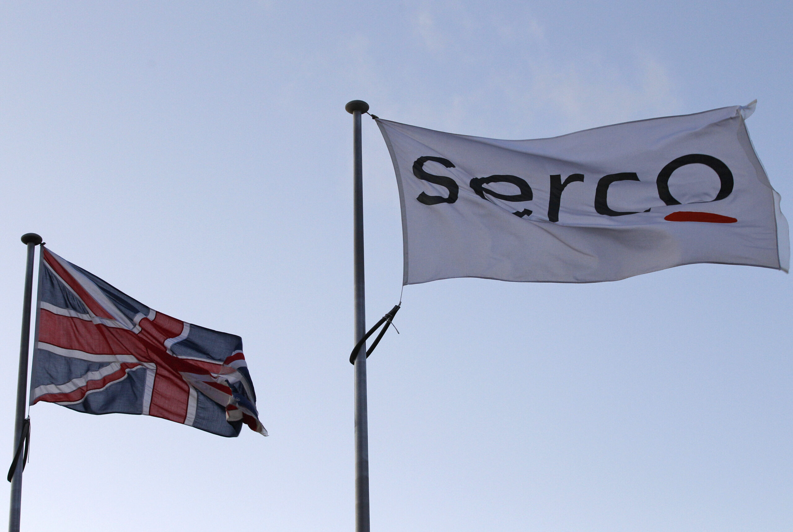 Two flags, one union jack, one says "Serco".