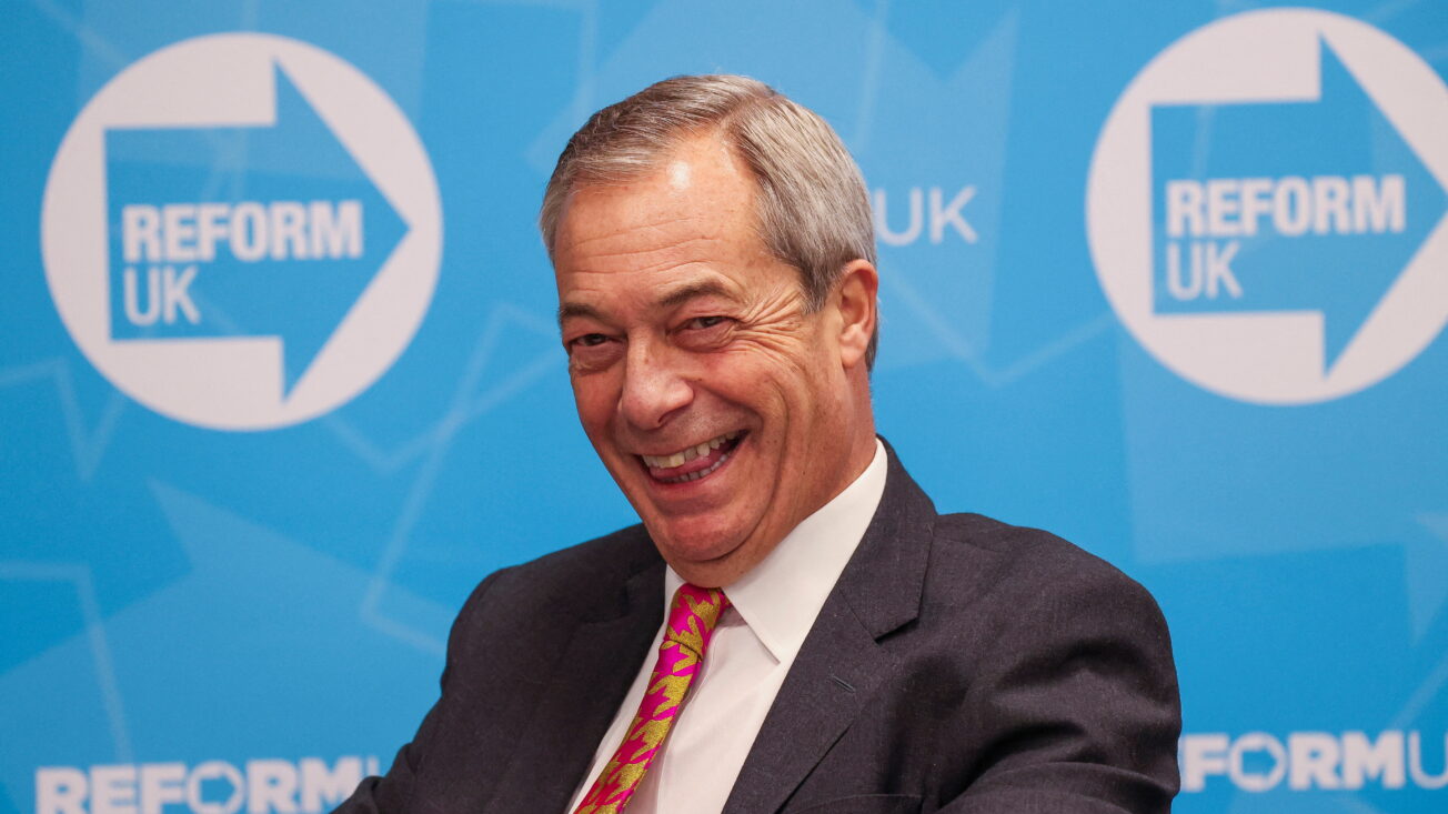Nigel Farage in front of the Reform UK logo