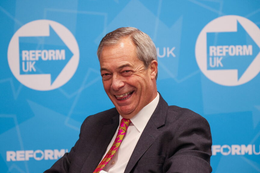 Nigel Farage in front of the Reform UK logo