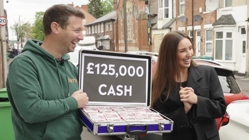 man and woman hold briefcase of prize money