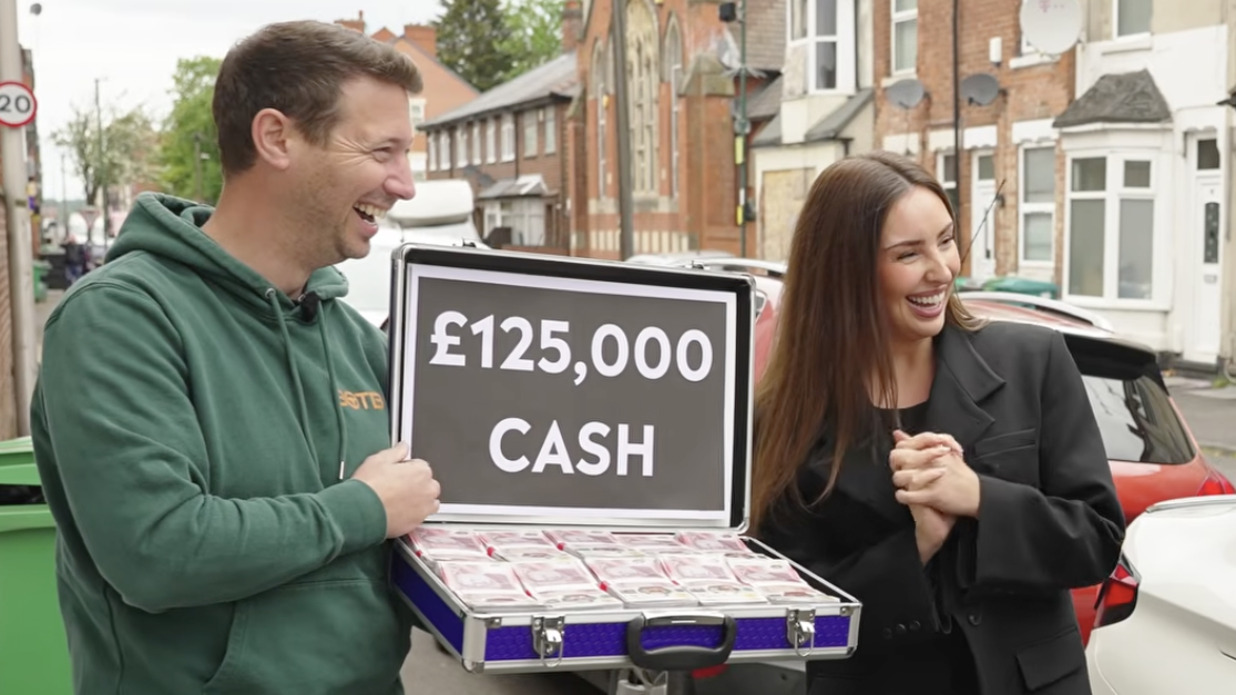 man and woman hold briefcase of prize money