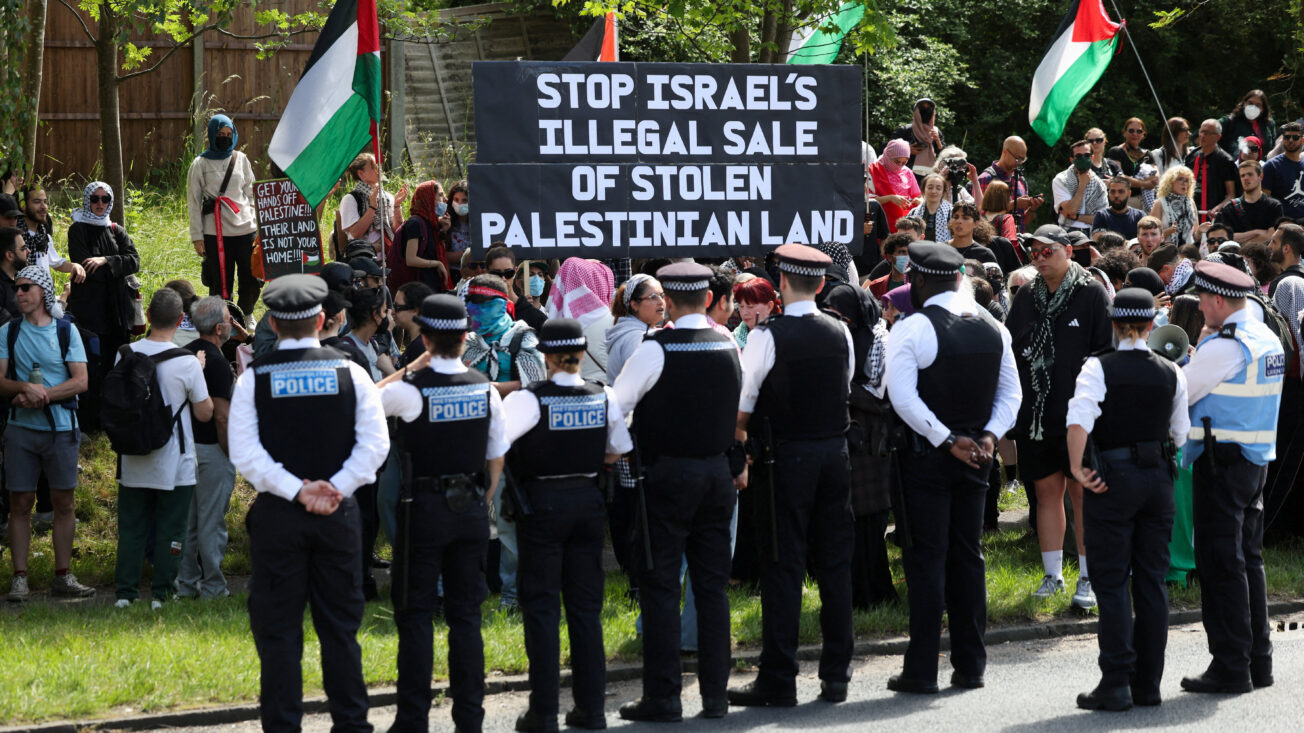 a line of police in front of pro-Palestine demonstrators