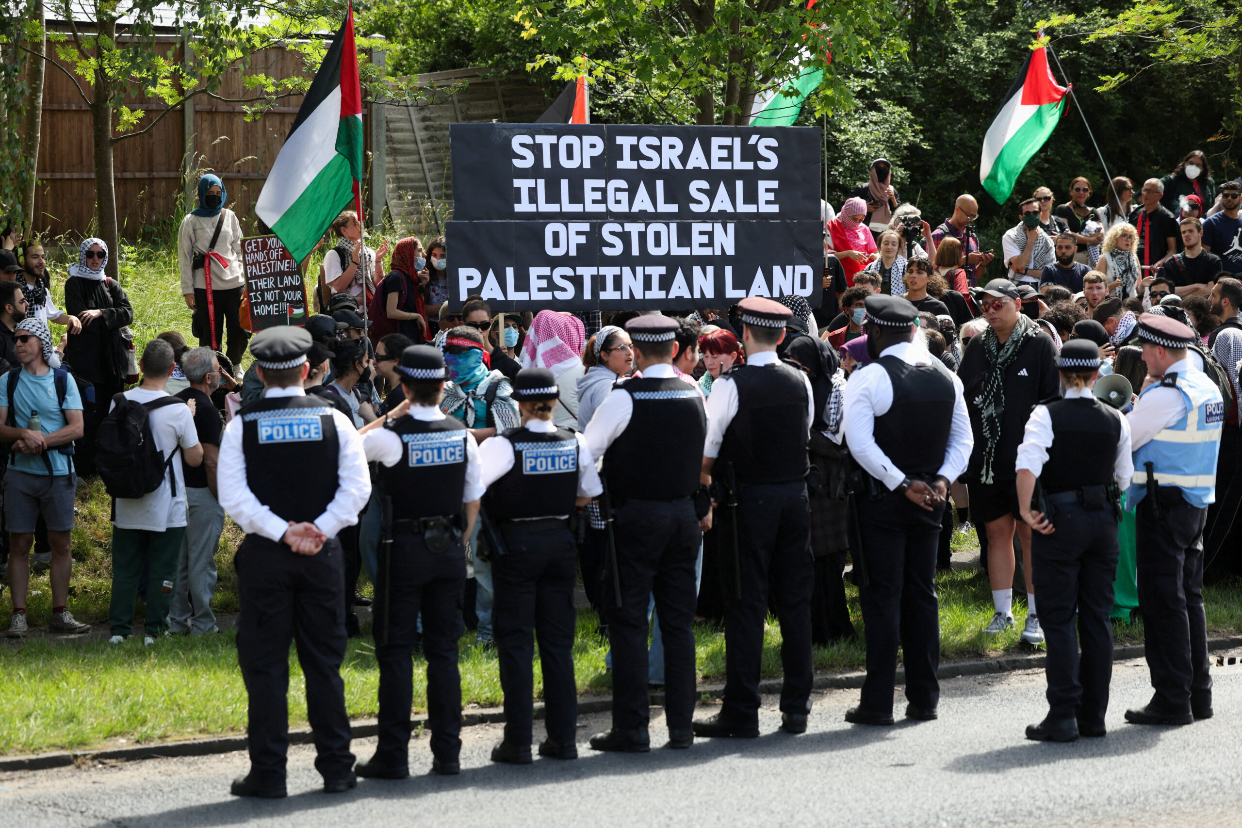 a line of police in front of pro-Palestine demonstrators