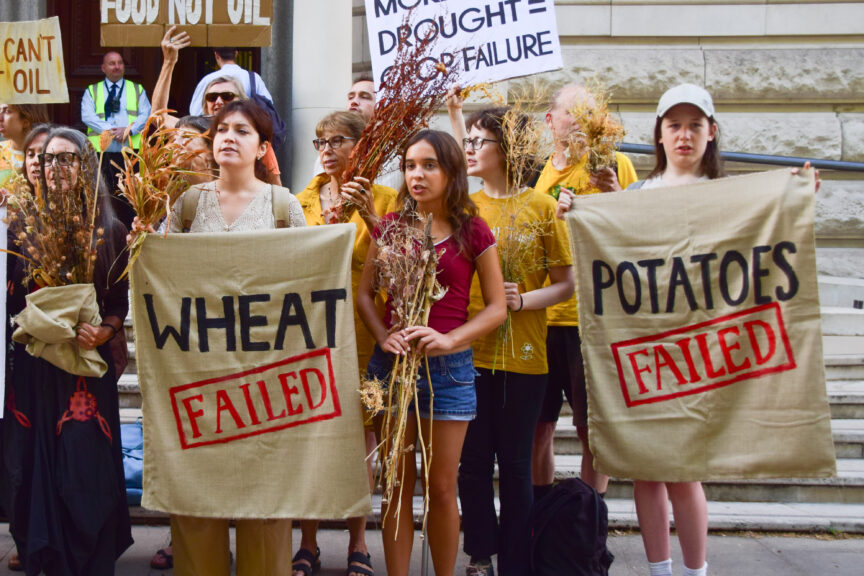 Protesters hold signs reading