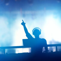 Club, disco DJ playing and mixing music for people.